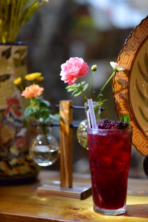 Free Chilled blackberry beverage with vibrant flowers on a wooden table setting. Stock Photo