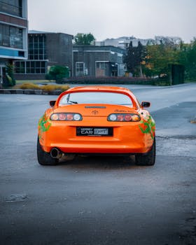 A vivid orange Toyota Supra parked on an urban street in Ankara, Türkiye.