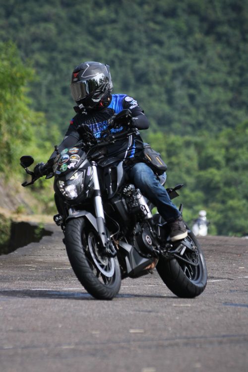 Free A motorcyclist skillfully navigates a curve on a scenic mountain road, showcasing agility and speed. Stock Photo