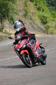 Motorcyclist in gear maneuvers a sharp curve on a scenic mountain road.