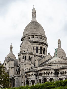 Explore the iconic Sacre-Coeur Basilica in Paris, a stunning architectural marvel under cloudy skies.