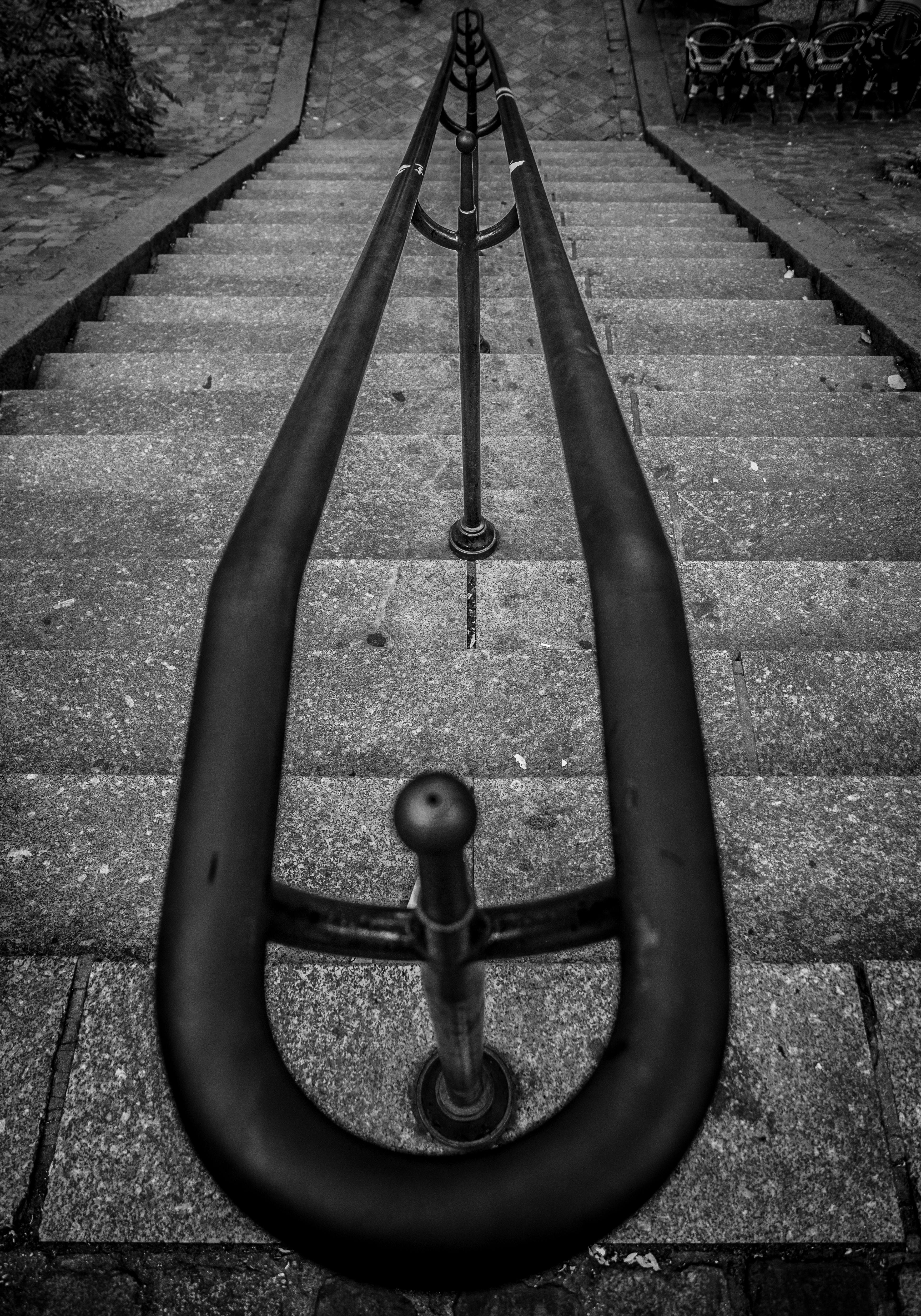 Moody black and white photo of a staircase with rail in Paris, France.