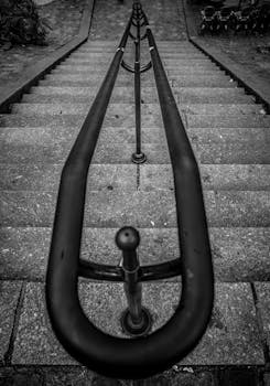 Moody black and white photo of a staircase with rail in Paris, France.