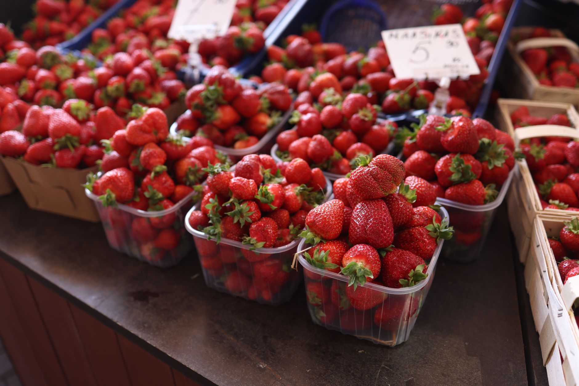 Felrode aardbeien in manden op een openluchtmarkt, een toonbeeld van versheid en overvloed.