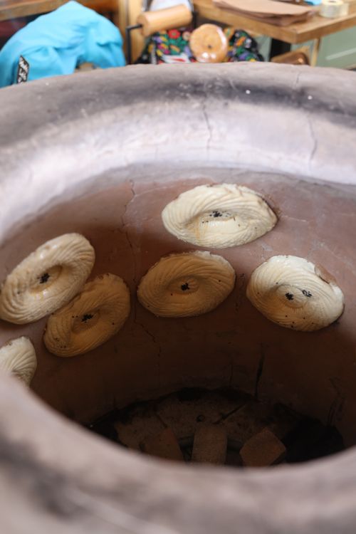 Free A close-up view of traditional flatbreads baking inside a tandoor oven. Stock Photo
