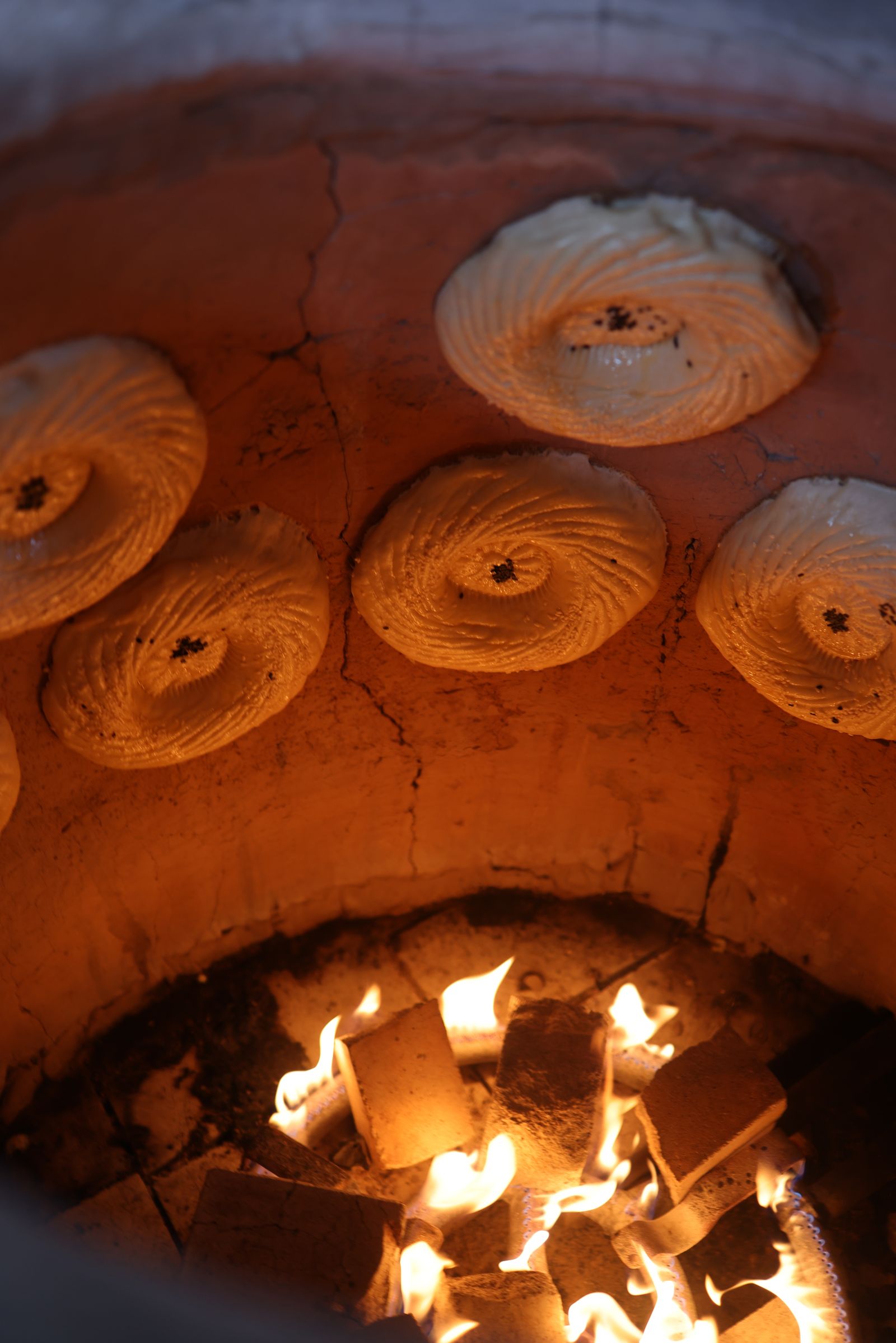 Flatbreads baking in a tandoor oven