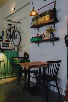 Charming cafe interior with vintage decor, bike on wall, and wooden furniture.