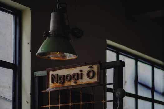 Vintage industrial design with hanging lamp and wooden sign indoors.