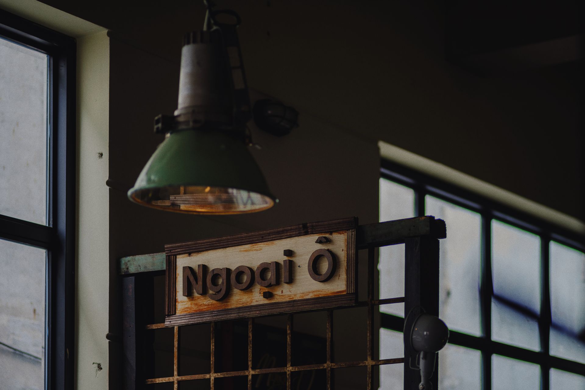 Vintage industrial design with hanging lamp and wooden sign indoors.