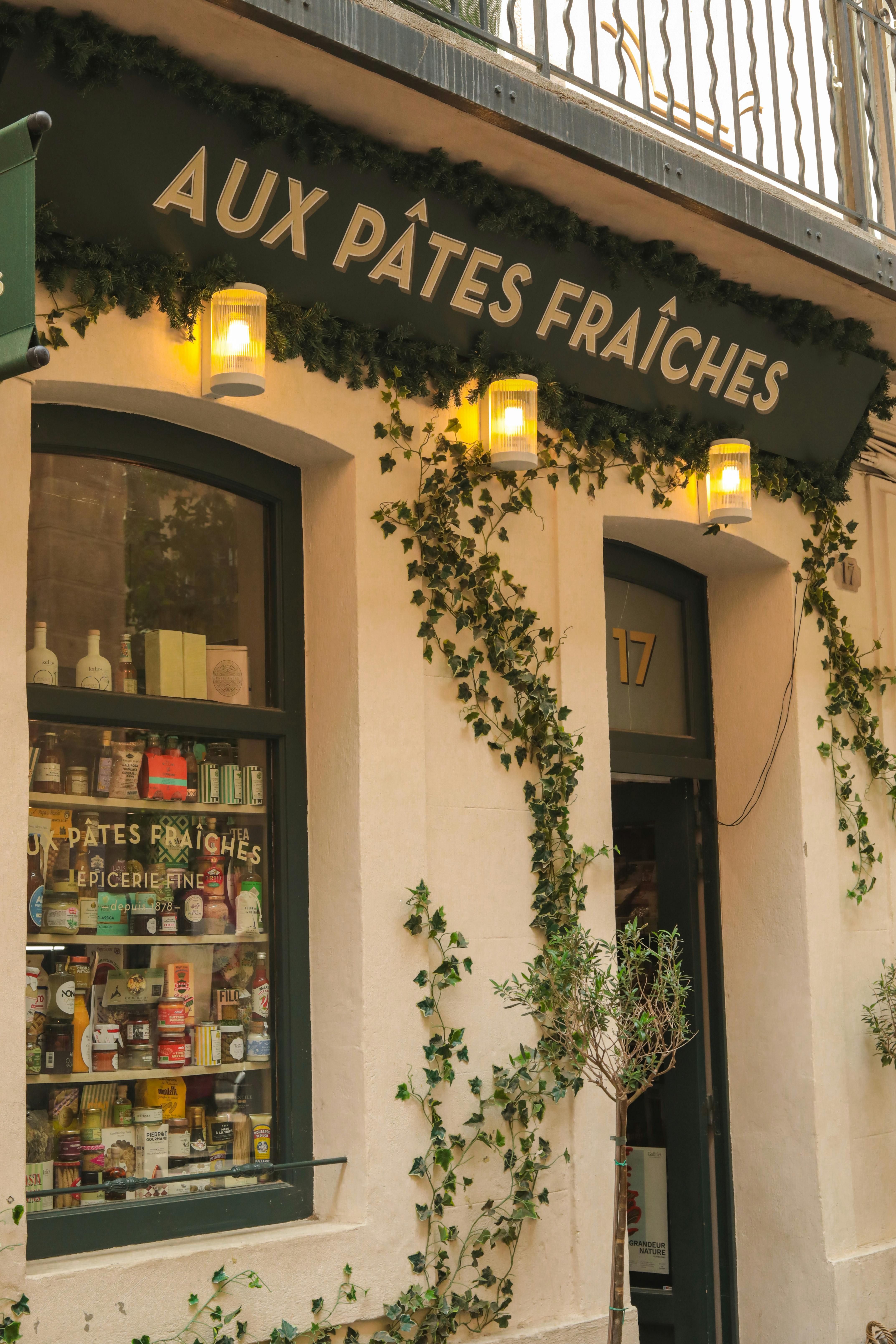 Cozy French bakery storefront with ivy and warm lighting, inviting atmosphere.