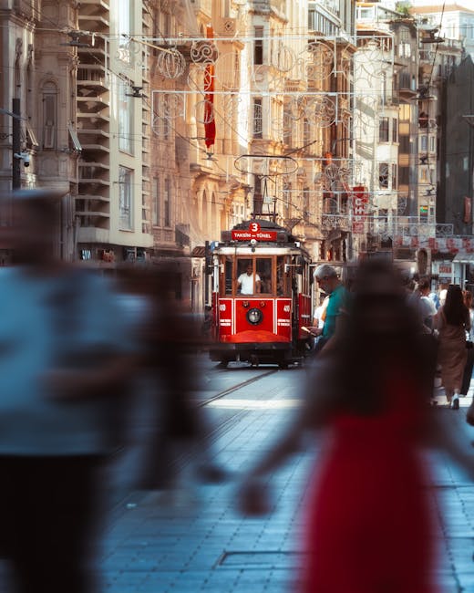 Iconic red tram on bustling Istiklal Avenue, Istanbul, capturing city life and Turkish culture.