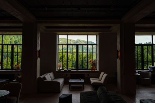Elegant lounge interior with a breathtaking mountain view through large windows.
