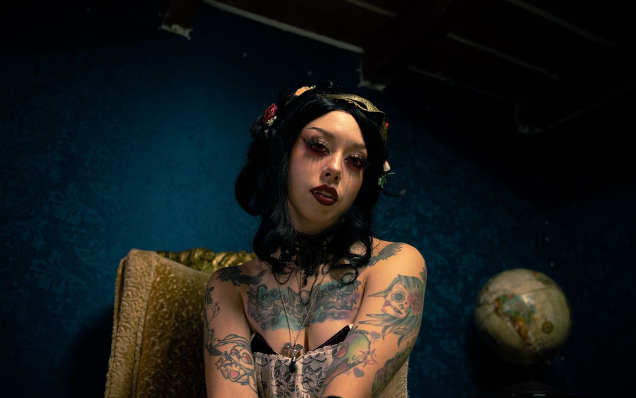 portrait of a tattooed woman with gothic makeup in vintage setting