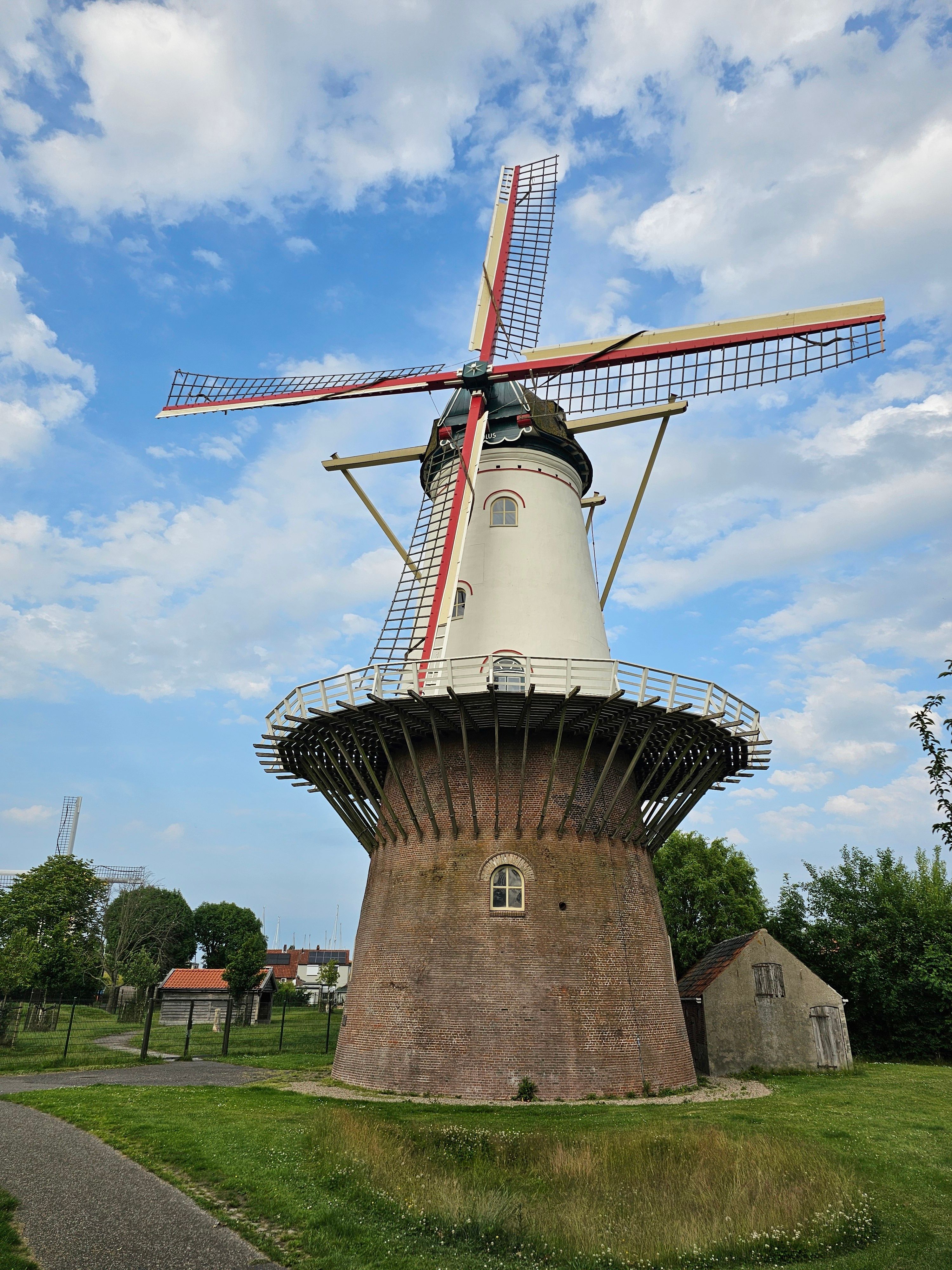 Charming Dutch windmill in a rural outdoor setting under a blue sky with clouds.