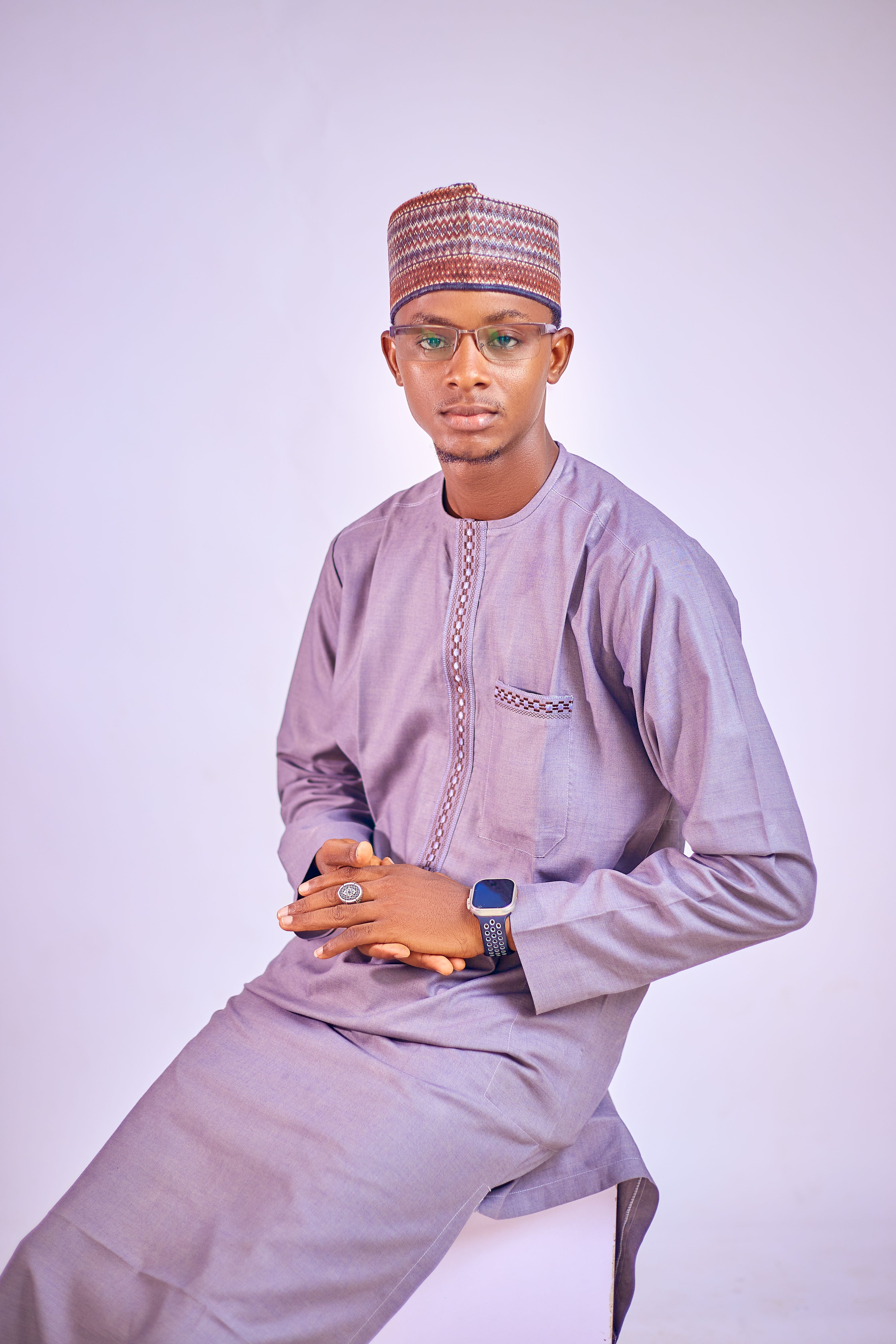 Adult wearing traditional attire and accessories in a studio setting.