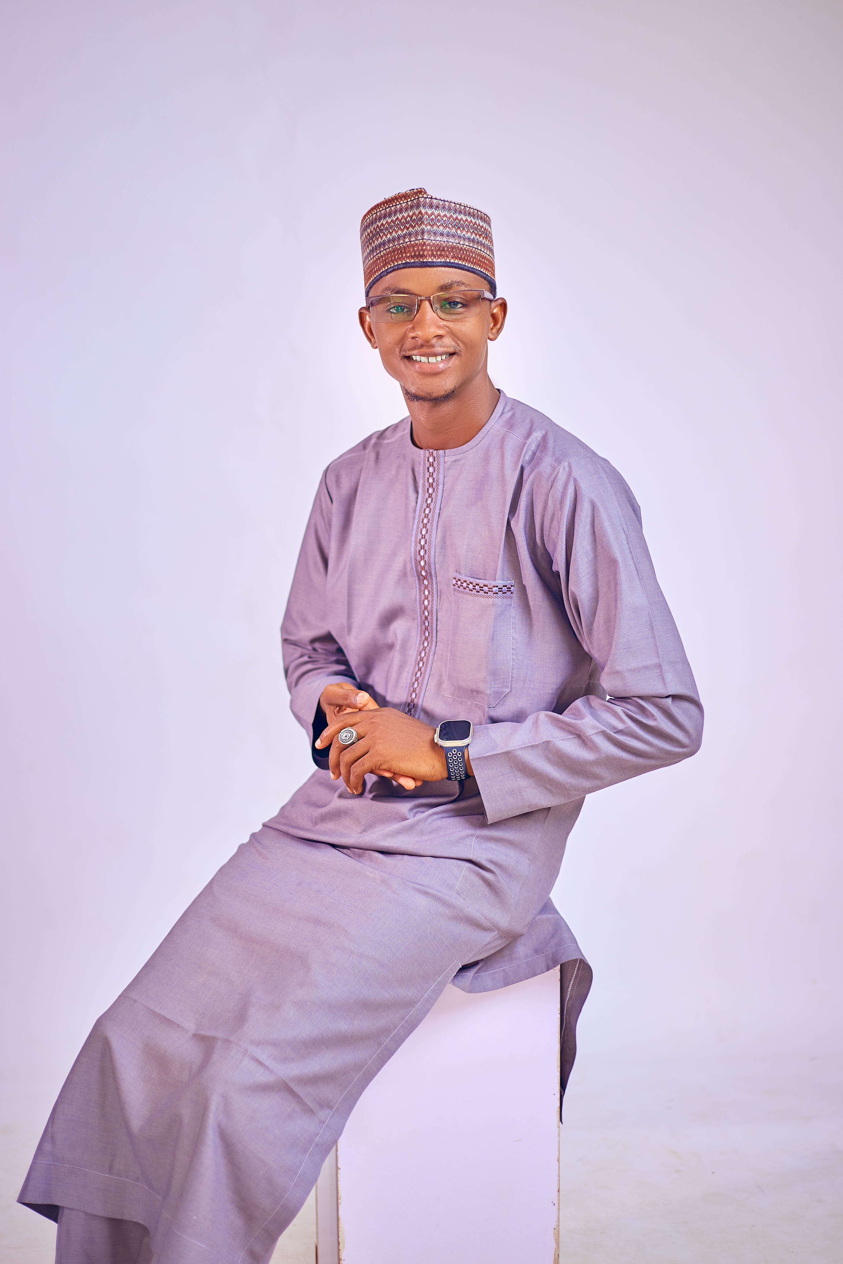 Portrait of a smiling man wearing traditional African attire with a stylish cap.