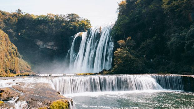 Stunning view of Huangguoshu Waterfall cascading amidst lush greenery in Guizhou, China.