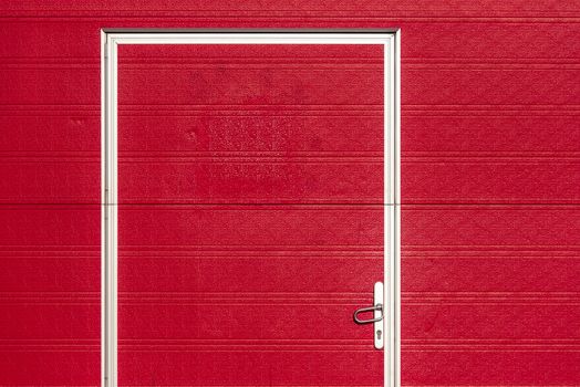 Minimalist image of a bold red garage door with a white frame and textured surface.