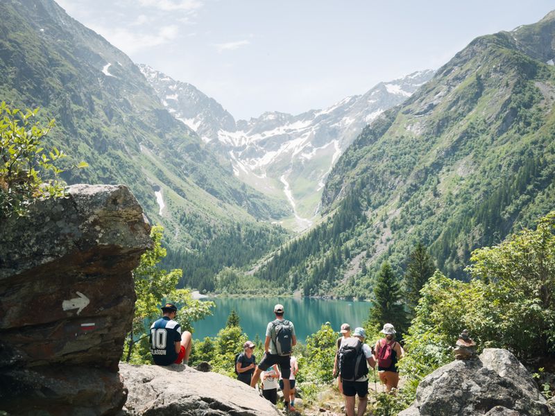 Group of hikers overlooking an alpine lake.