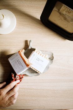 Flatlay of artisan soaps with minimal packaging on a wooden surface, featuring a unique design.