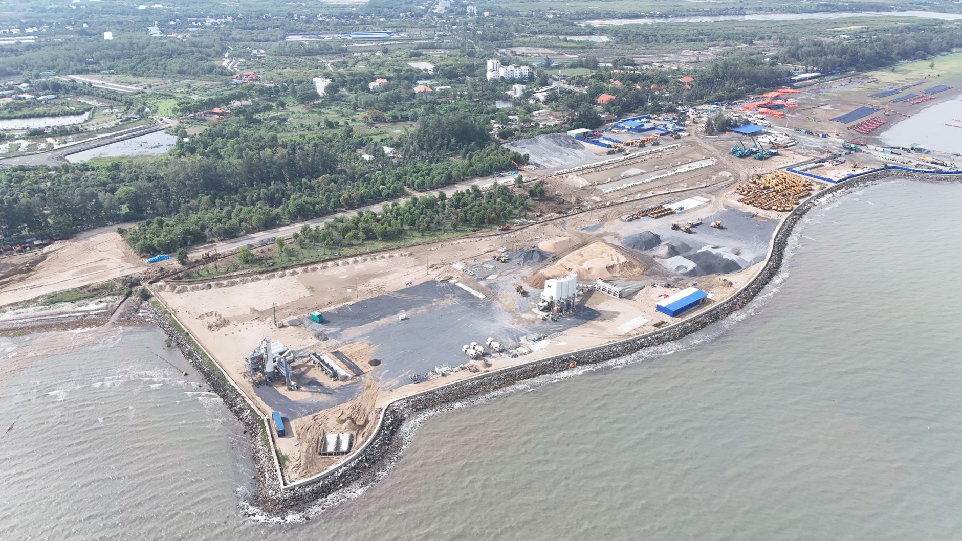 Aerial view of a coastal industrial area under development in Vietnam showcasing land and sea contrast.