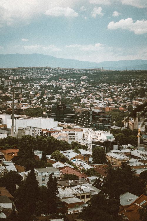 Free Scenic aerial shot of Tbilisi, Georgia, highlighting city architecture under a cloudy sky. Stock Photo