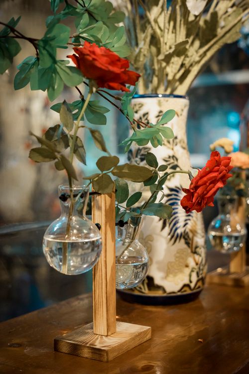 Free Artistic display of red roses in glass vases with elegant ceramic background. Stock Photo