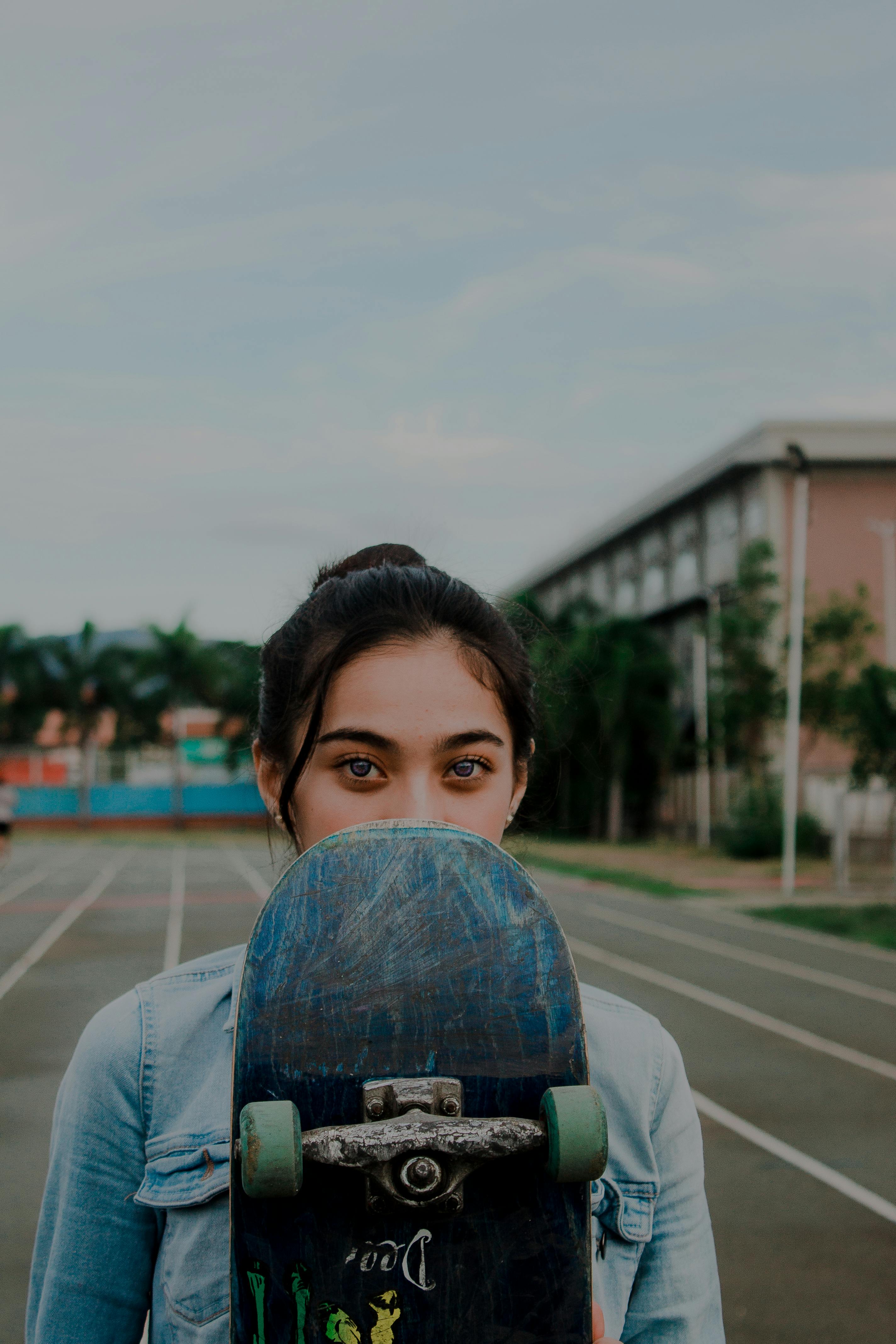 一名年轻女子在公园外拿着滑板