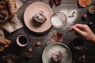 质朴的木桌上摆着撒了糖粉的肉桂卷和咖啡