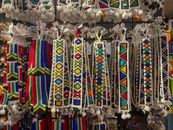 Colorful African beaded crafts hanging in a souvenir shop, showcasing traditional artistry.