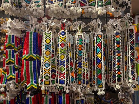 Colorful African beaded crafts hanging in a souvenir shop, showcasing traditional artistry.