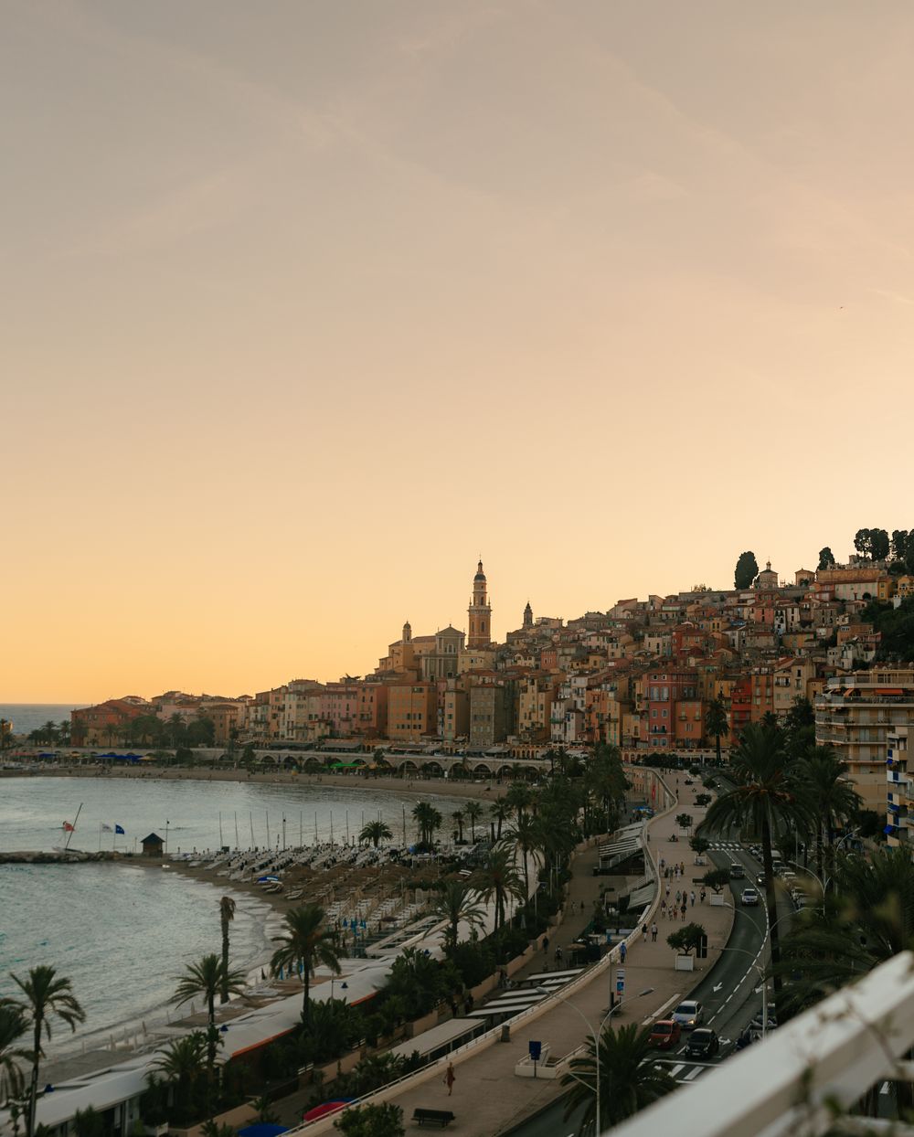 Orașul Menton la apus, cu fațade colorate pe malul mării