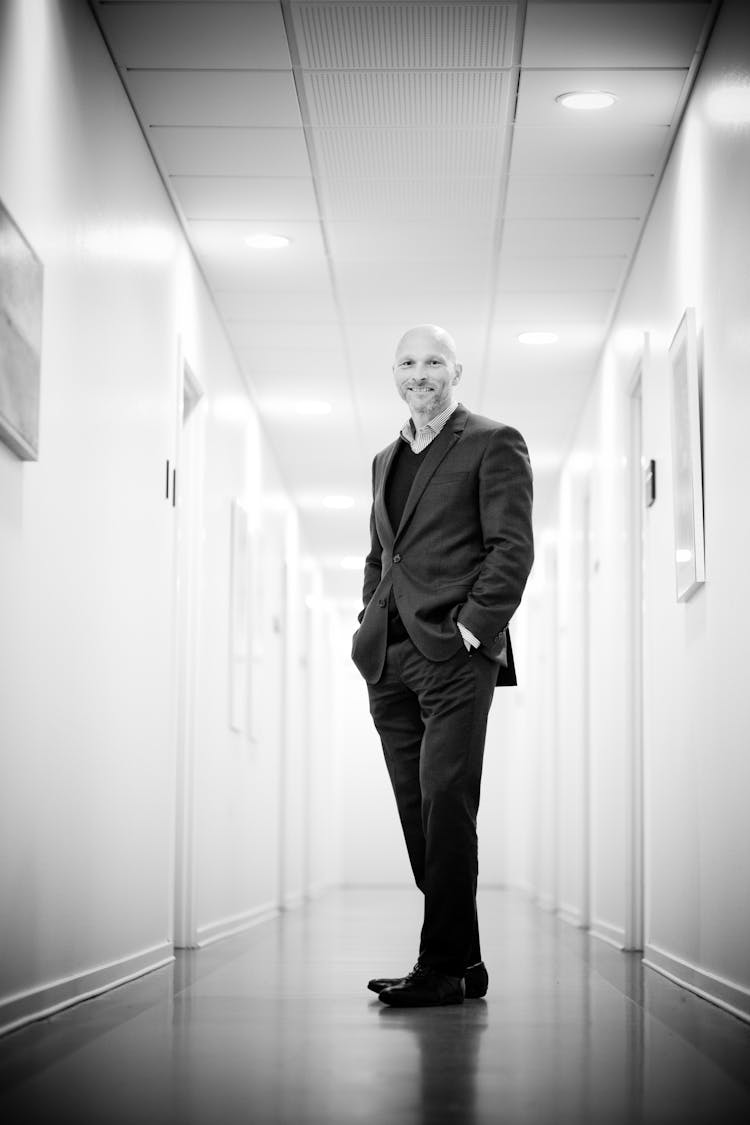 Full Length Portrait Of Man Standing In Corridor