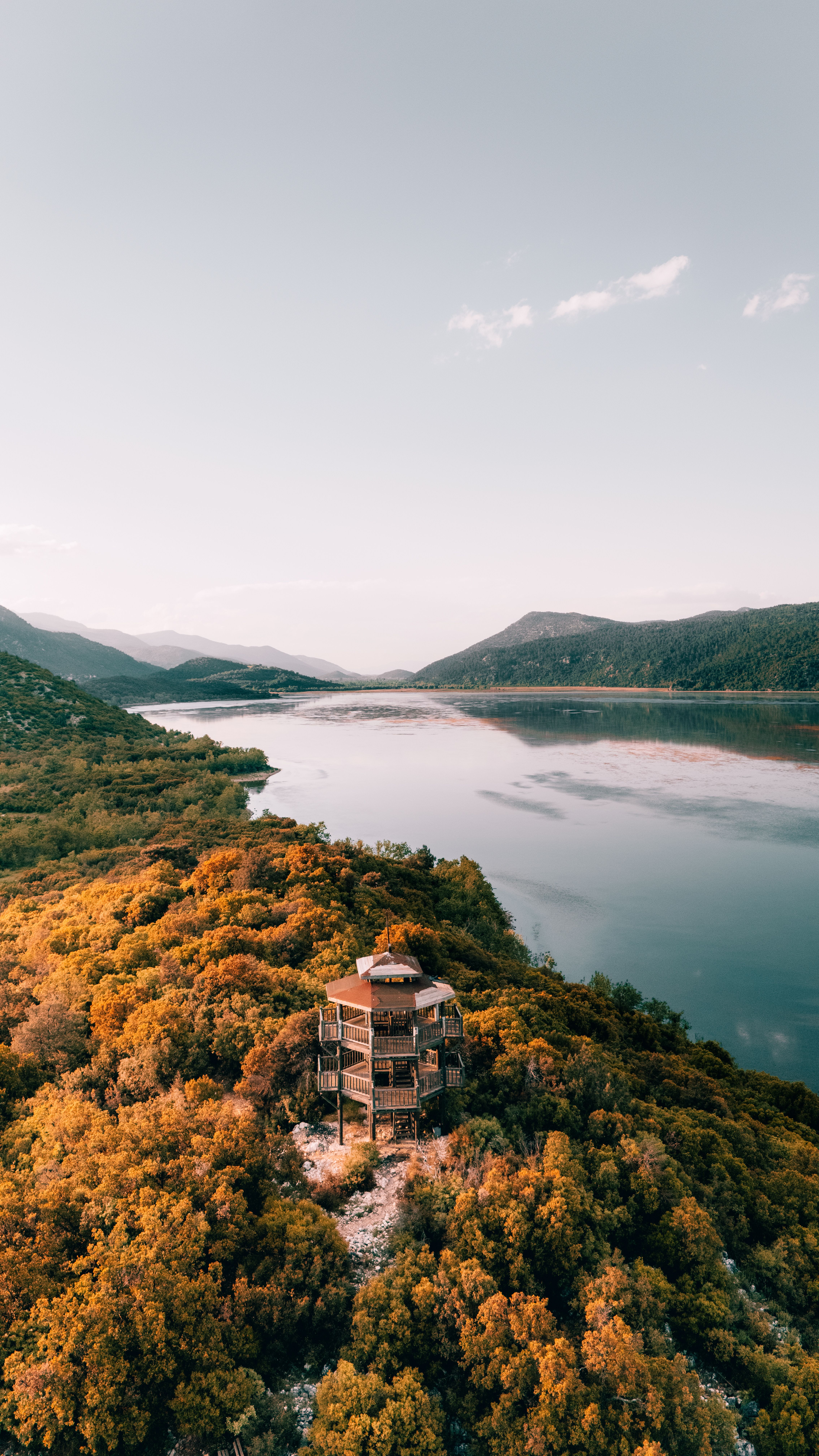 Breathtaking aerial view of a serene lake surrounded by autumn foliage in Isparta, Türkiye.
