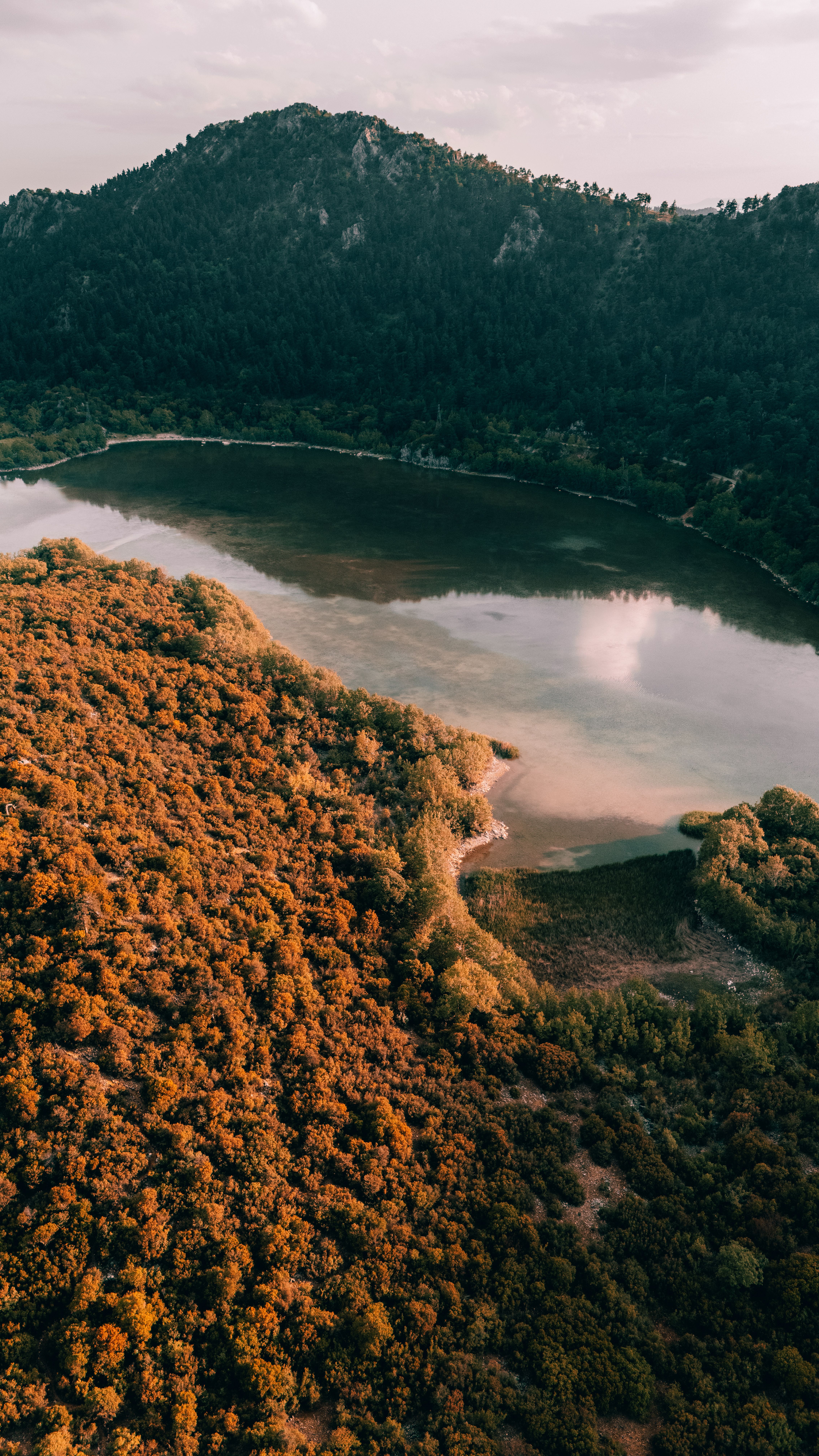 Serene aerial view showcasing autumn colors around a tranquil lake in Isparta, Türkiye.
