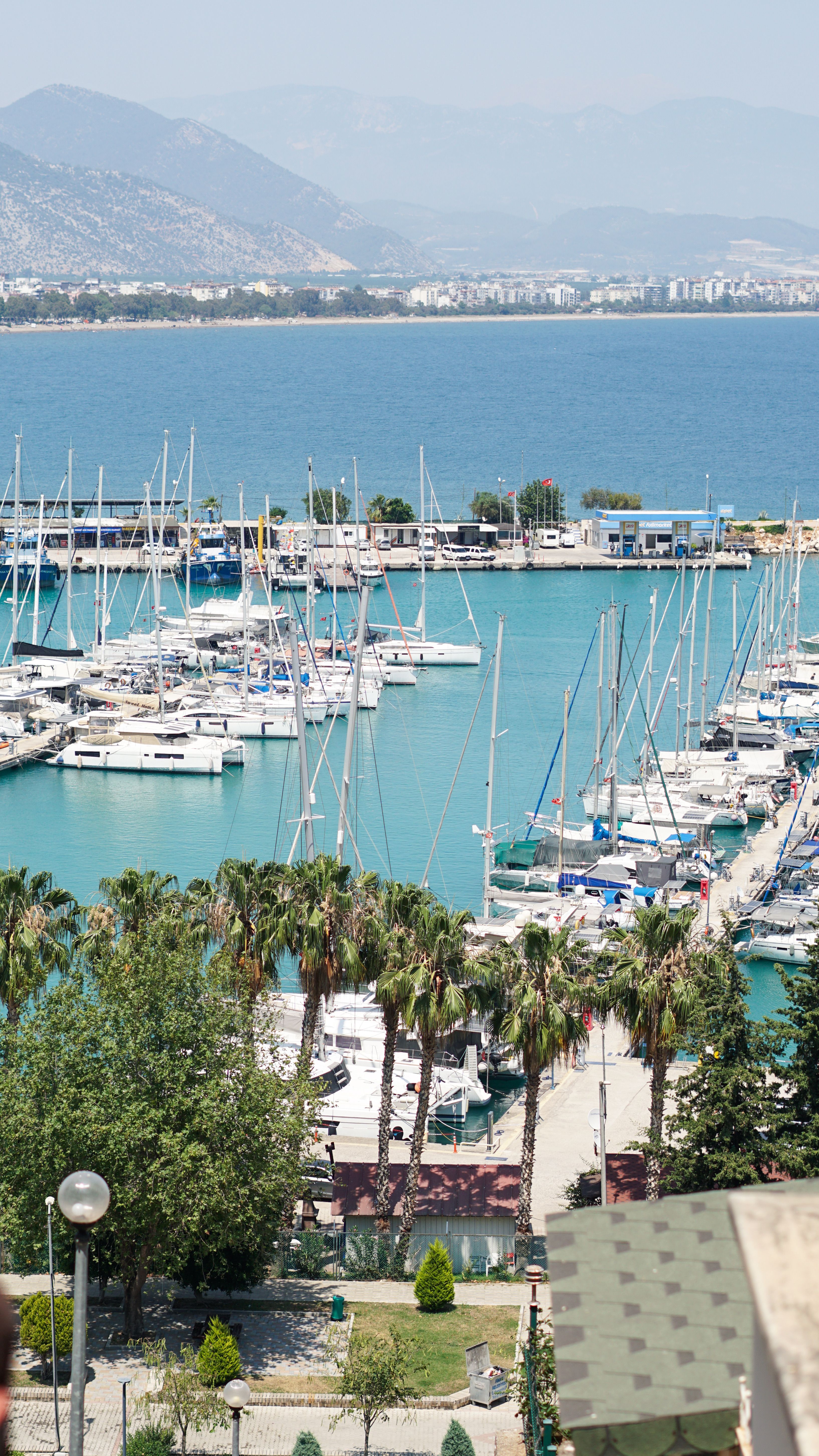 Aerial view of a vibrant marina with yachts and boats during a sunny summer day.