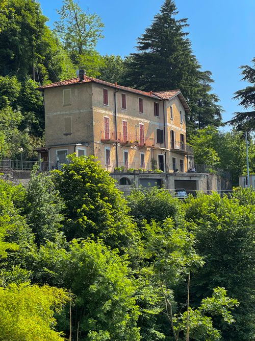 Free Picturesque Italian villa nestled amidst vibrant greenery, ideal for tourism imagery. Stock Photo