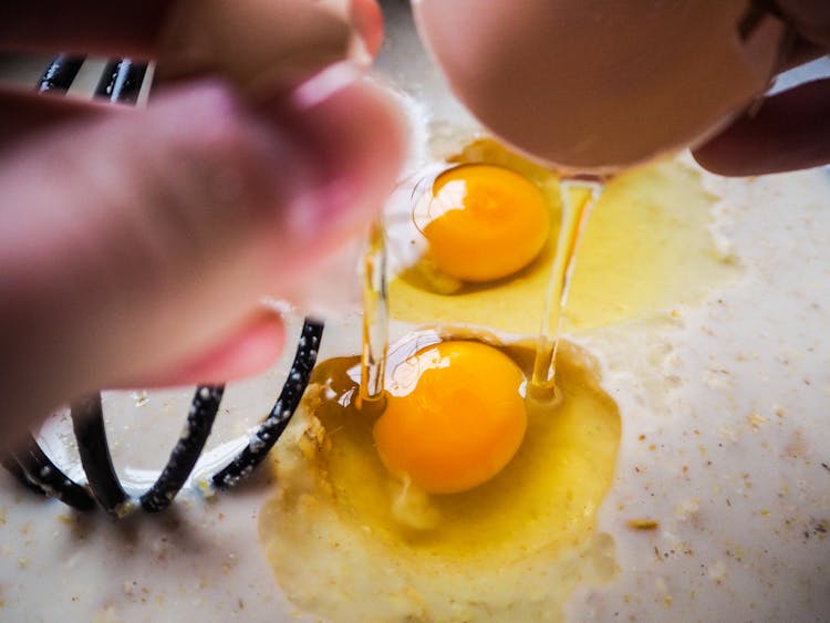 Close-Up Shot Of A Person Cracking An Egg