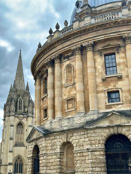Stunning view of Oxford University's Radcliffe Camera and surrounding architecture under a cloudy sky.