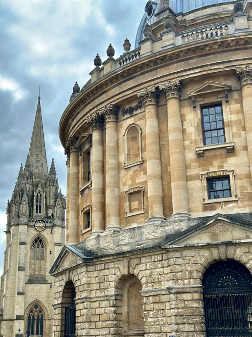 Free Stunning view of Oxford University's Radcliffe Camera and surrounding architecture under a cloudy sky. Stock Photo