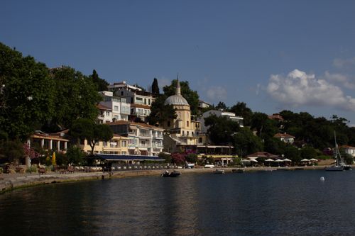 Free Beautiful view of a coastal village with historic buildings and lush greenery overlooking the sea. Stock Photo
