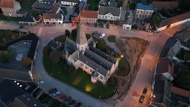 Drone shot of a church in Gavere, Belgium, showcasing its architectural beauty and surrounding area.