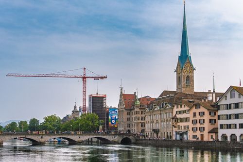 View of Zürich cityscape featuring Fraumünster Church and Limmat River during a summer day.