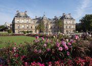 Beautiful view of Luxembourg Palace and its vibrant gardens in Paris, showcasing historic architecture and blooming flowers.