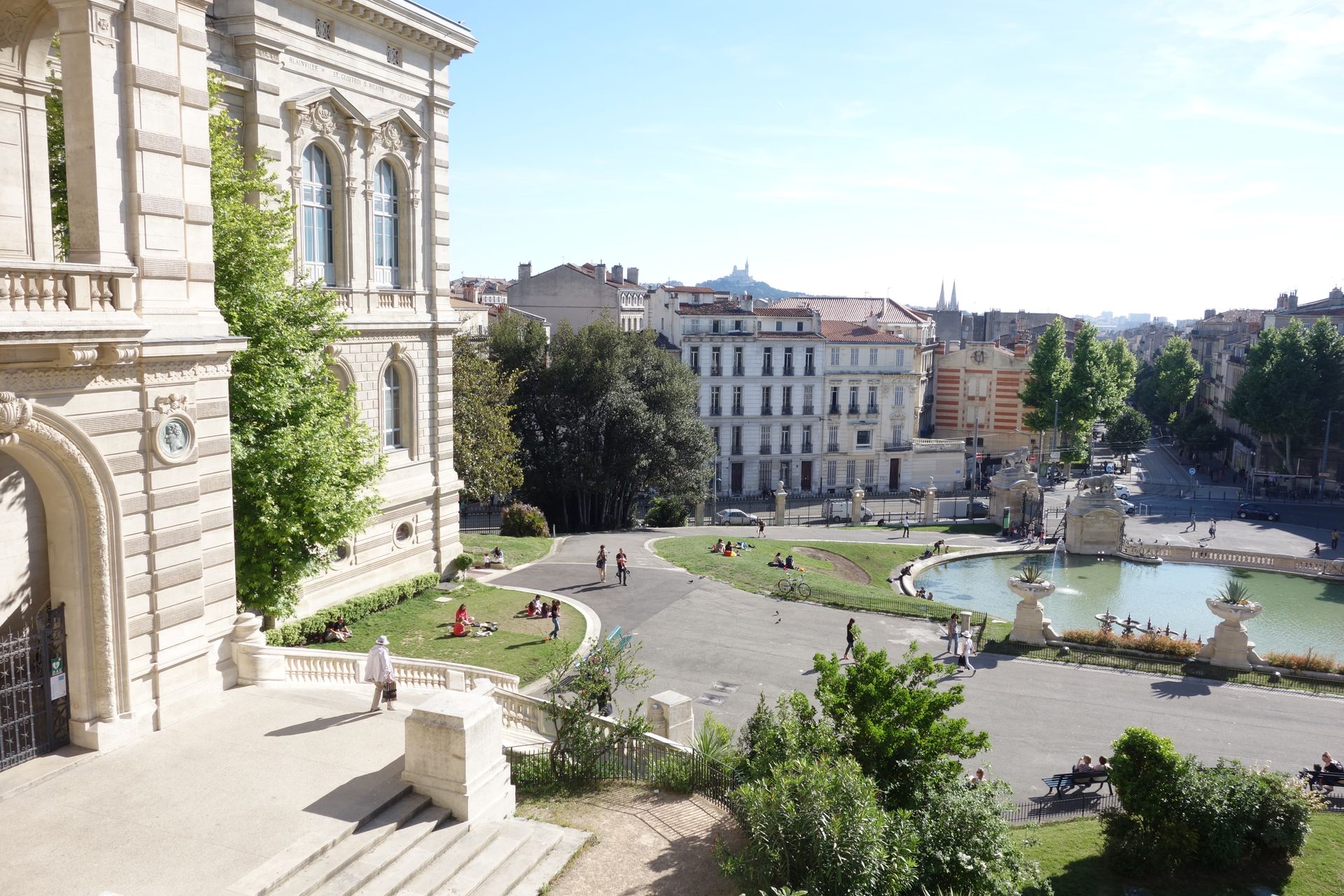 People enjoying a sunny day at Palais Longchamp in Marseille, France.