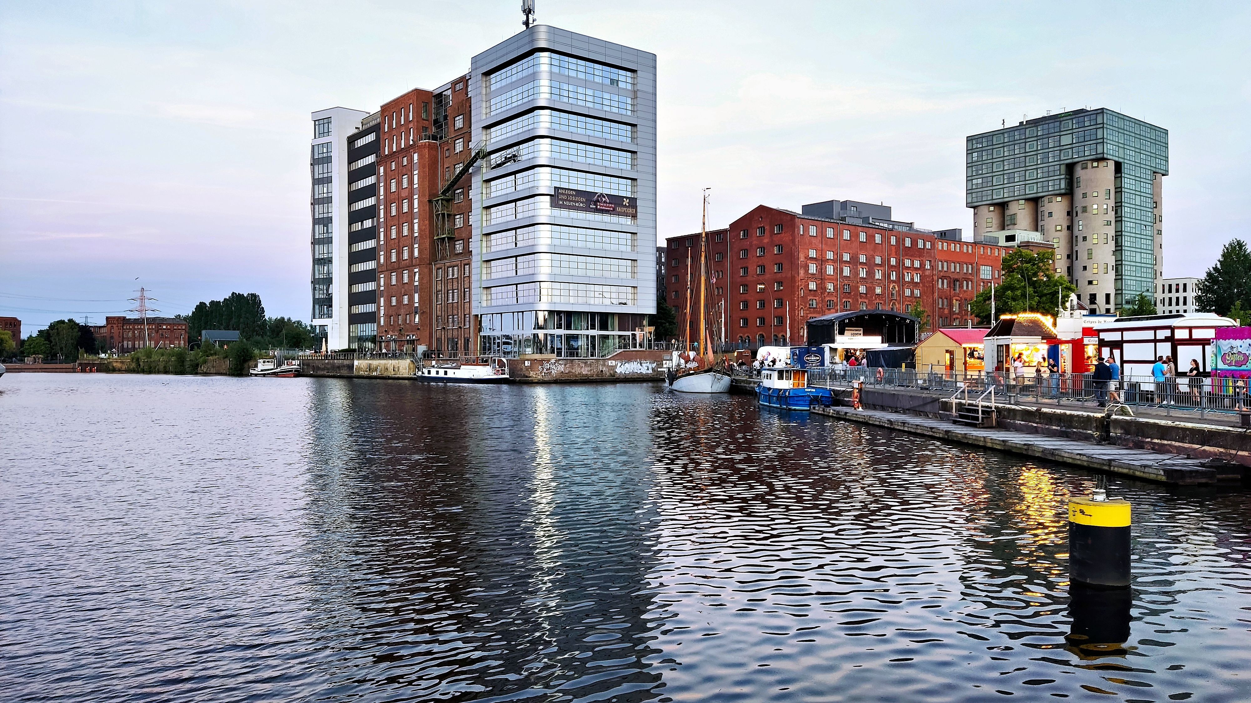 Scenic view of urban waterfront with modern buildings and reflections on water at dusk.