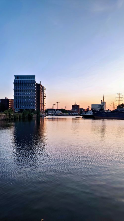 Free A serene sunset over Hamburg's HafenCity with reflections in the water and modern architecture. Stock Photo