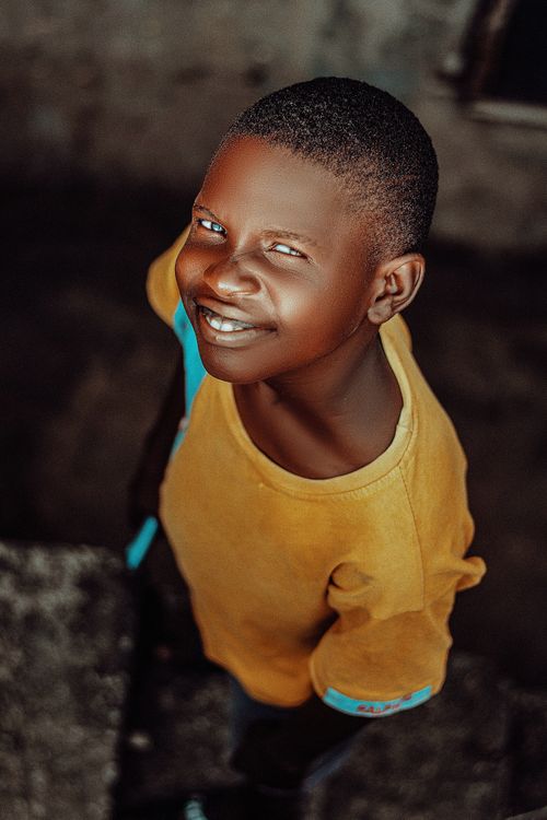 Free A cheerful African boy beams at the camera with a bright smile in an outdoor setting in Nigeria. Stock Photo