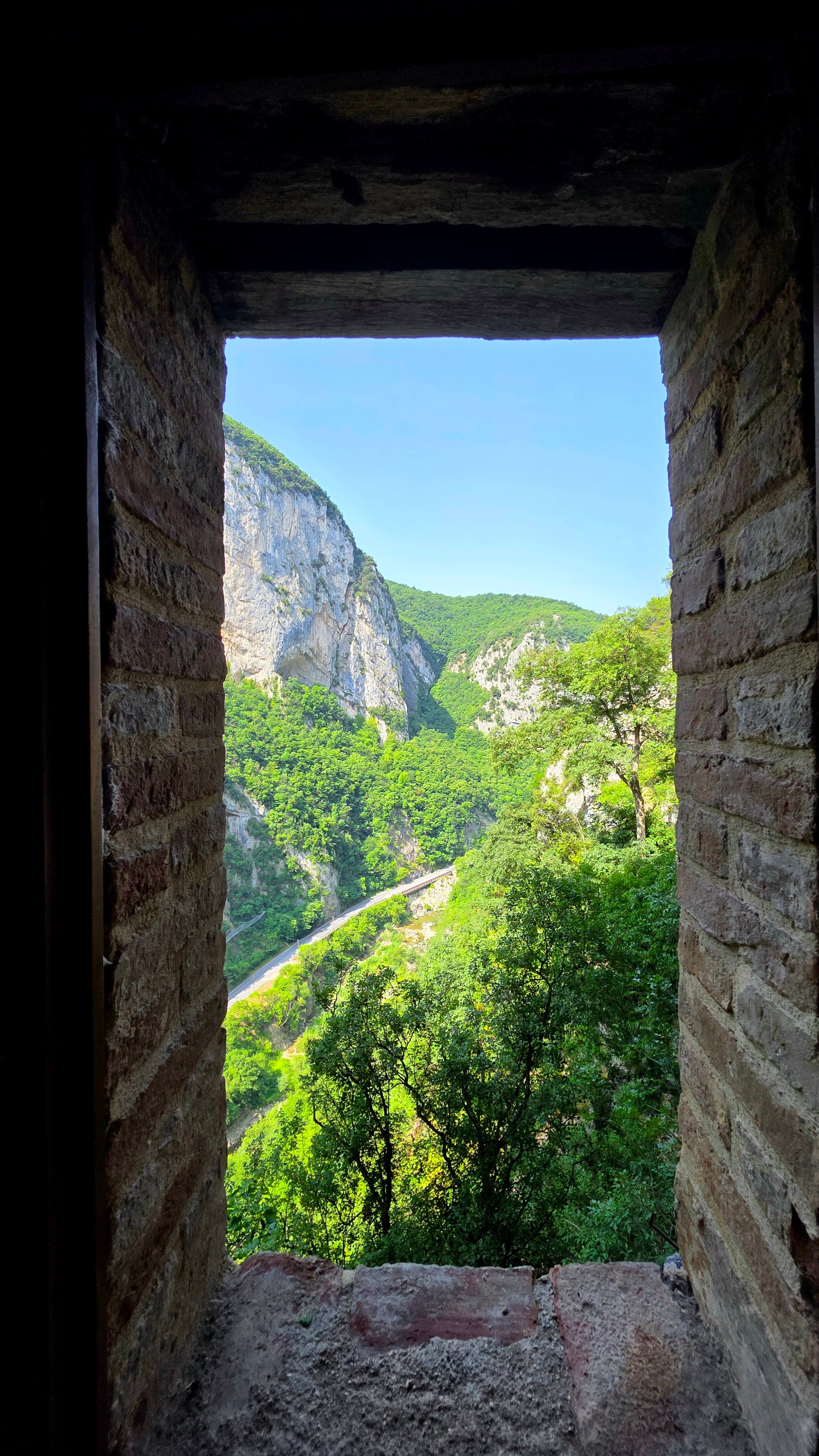 Captivating view of a canyon framed by a rustic brick window.