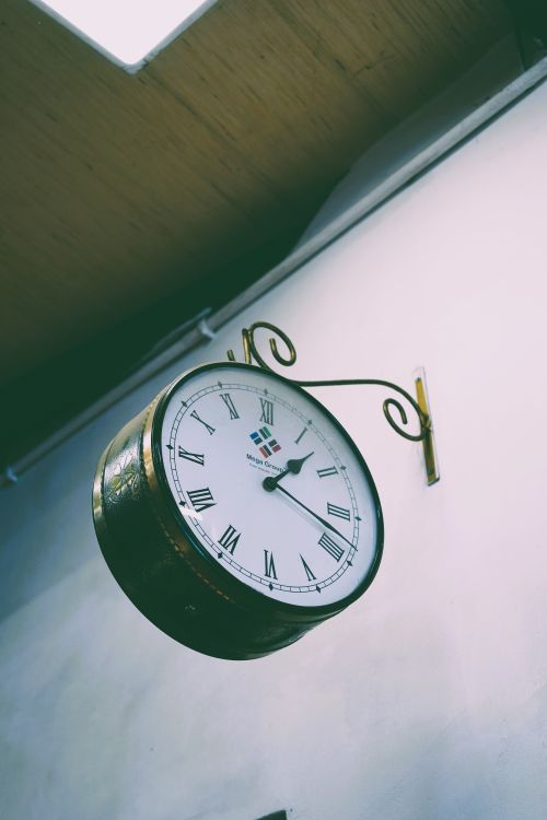 Free Antique wall clock displaying Roman numerals in a classic setting. Perfect for vintage decor themes. Stock Photo